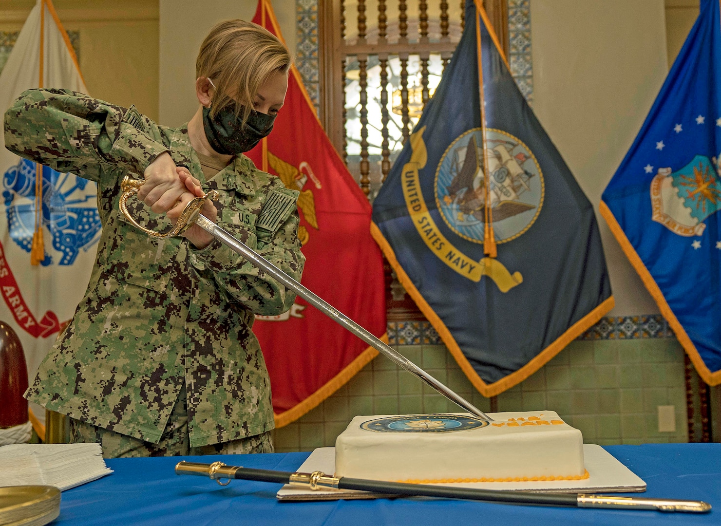 Lt. Cmdr. Kellie Haney, the executive assistant of Naval Medical Forces Support Command (NMFSC), the junior nurse at NMFSC cuts a cake in honor of the Navy Nurse Corps 112th birthday.