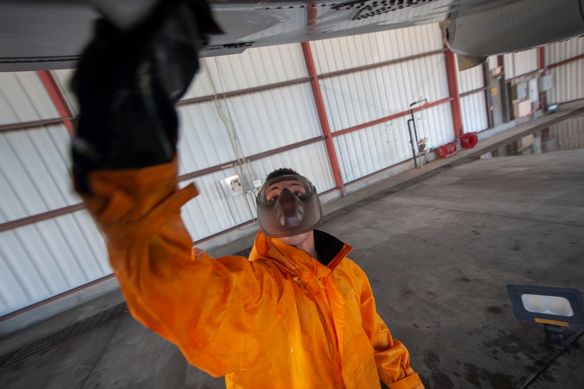 A photo of an Airman scrubbing an aircraft