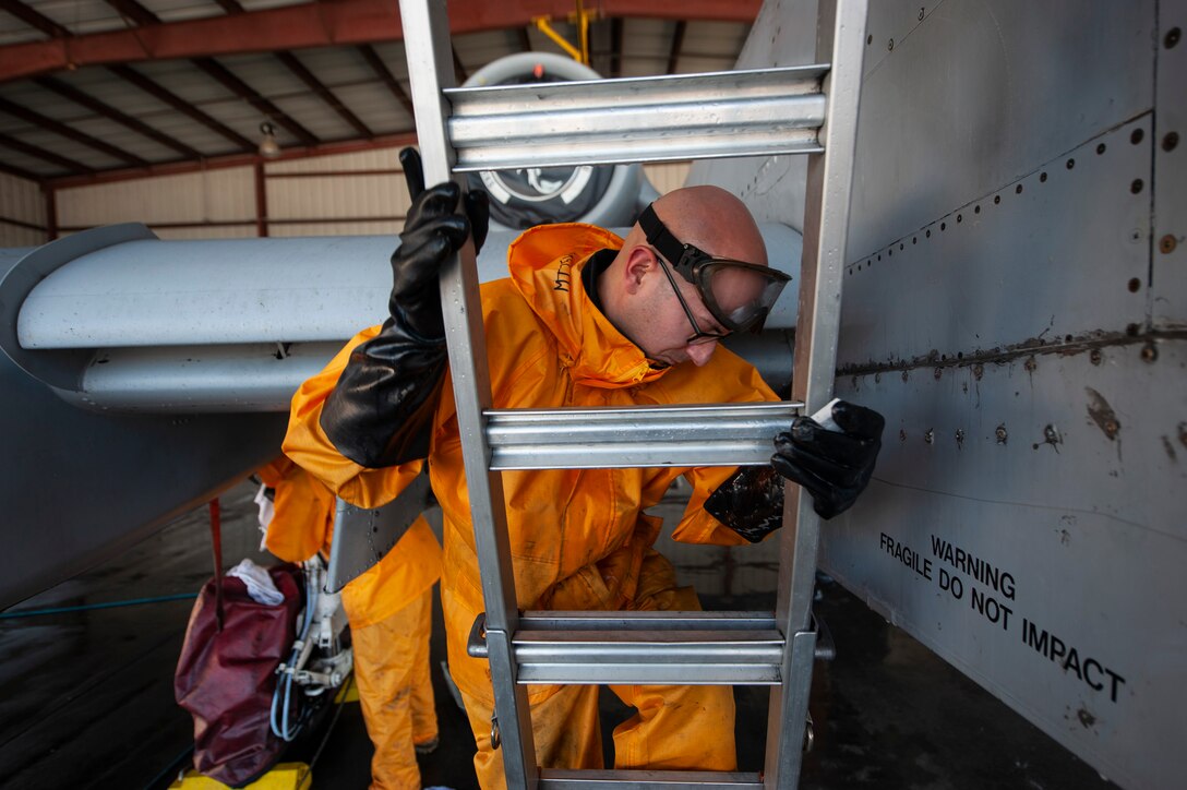 A photo of an Airman climbing a ladder
