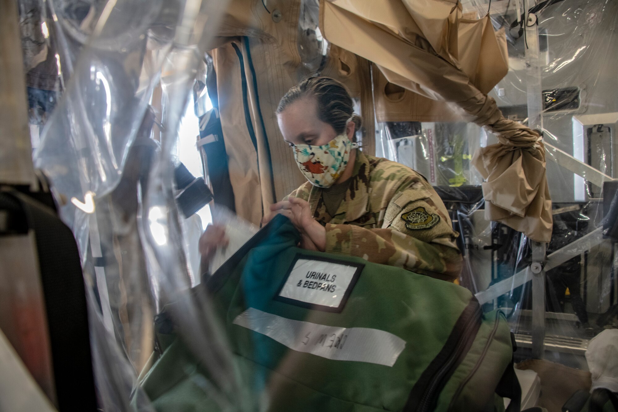 U.S. Air Force Capt. Morgan Kavachevich, 43rd Aeromedical Evacuation Squadron flight nurse 4 from Pope Army Airfield, North Carolina, organizes medical supplies inside a Transport Isolation System capsule on board a C-17 Globemaster III during a training exercise May 7, 2020, at Travis Air Force Base, California. The training focused on receiving and caring for potential COVID-19 patients using TIS capsules. Travis AFB has a - C-17 loaded with a TIS capsule on alert status to ensure the aircraft is ready to launch at a moment’s notice. The TIS unit allows the transport of individuals with highly contagious diseases without infecting other passengers or aircrew on the aircraft. (U.S. Air Force photo by Heide Couch)
