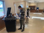 Spc. Lincoln Meverden and Pfc. Napatsawan Sanguanboon, both of the 132nd Brigade Support Battalion, process ballots May 12 in Maine, Wisconsin. Approximately 160 Wisconsin National Guard Citizen-Soldiers mobilized to state active duty as poll workers supporting the 7th Congressional District special election in northern Wisconsin.