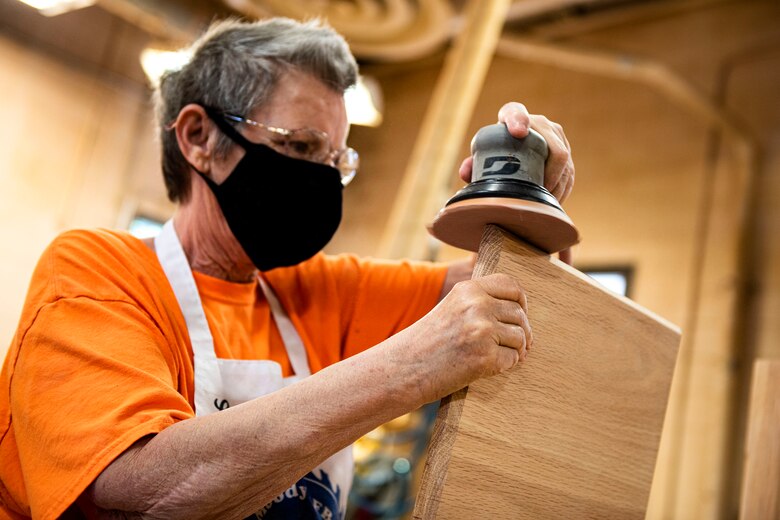 Photo of woodworker sanding a piece of wood.