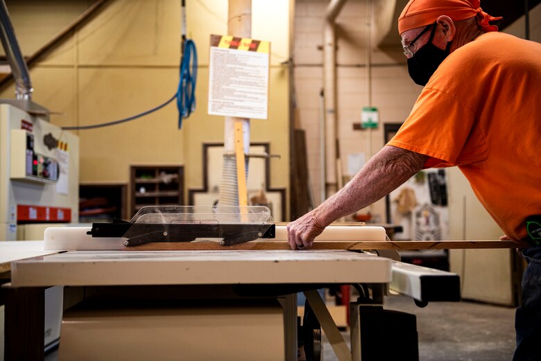 Photo of woodworker cutting wood.