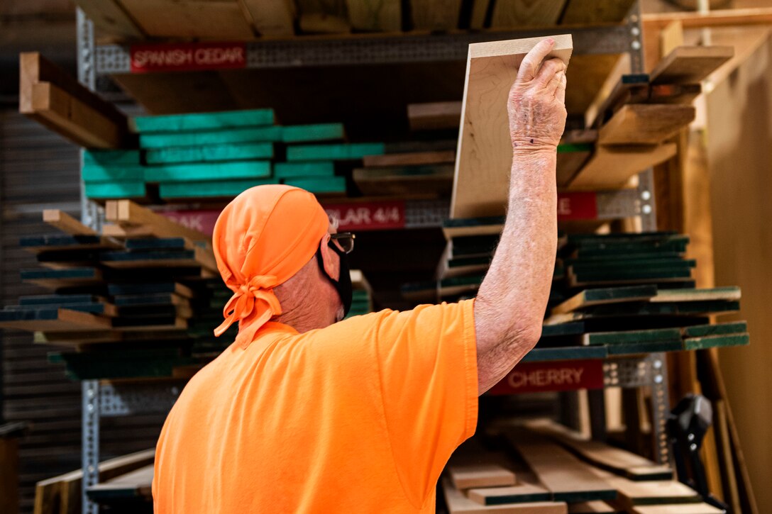Photo of woodworker grabbing a piece of wood.