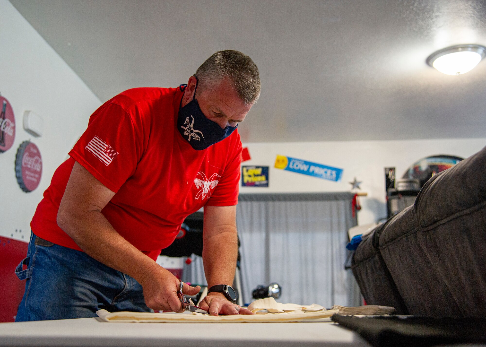 Tech. Sgt. Steven Wright, a fuels technician in the 419th Logistics Readiness Squadron, cuts out masks prior to his wife sewing them at their home in Nibley, Utah