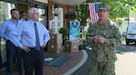 U.S. Navy Rear Admiral John Polowczyk, Federal Emergency Management Agency Supply Chain Task Force Lead speaks to the media as Vice President Michael Pence looks on in front Woodbine Rehabilitation & Healthcare Center, Alexandria, Va. where the first of $134 million worth of personal protective equipment kits were delivered May 7. The Defense Logistics Agency ordered the kits, which will be delivered to approximately 15,000 nursing homes throughout the U.S., to provide medical staff members with 14-days worth of protective eyewear, medical gowns, masks and nitrite gloves. The items were requested by the White House Coronavirus Task Force and funded by FEMA.