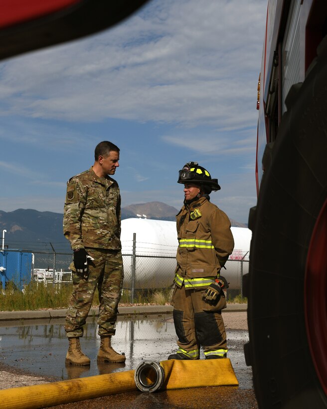 Col. Thomas Falzarano, 21st Space Wing commander, left, talks with Senior Airman Paul Karasiewicz, a 21st Civil Engineer Squadron firefighter Aug. 7, 2019, on Peterson Air Force Base, Colorado. Falzarano, as part of a tour of the 21st CES, met the many Airmen in the squadron and learned about what they do everyday. (U.S. Air Force photo by Airman 1st Class Andrew Bertain)