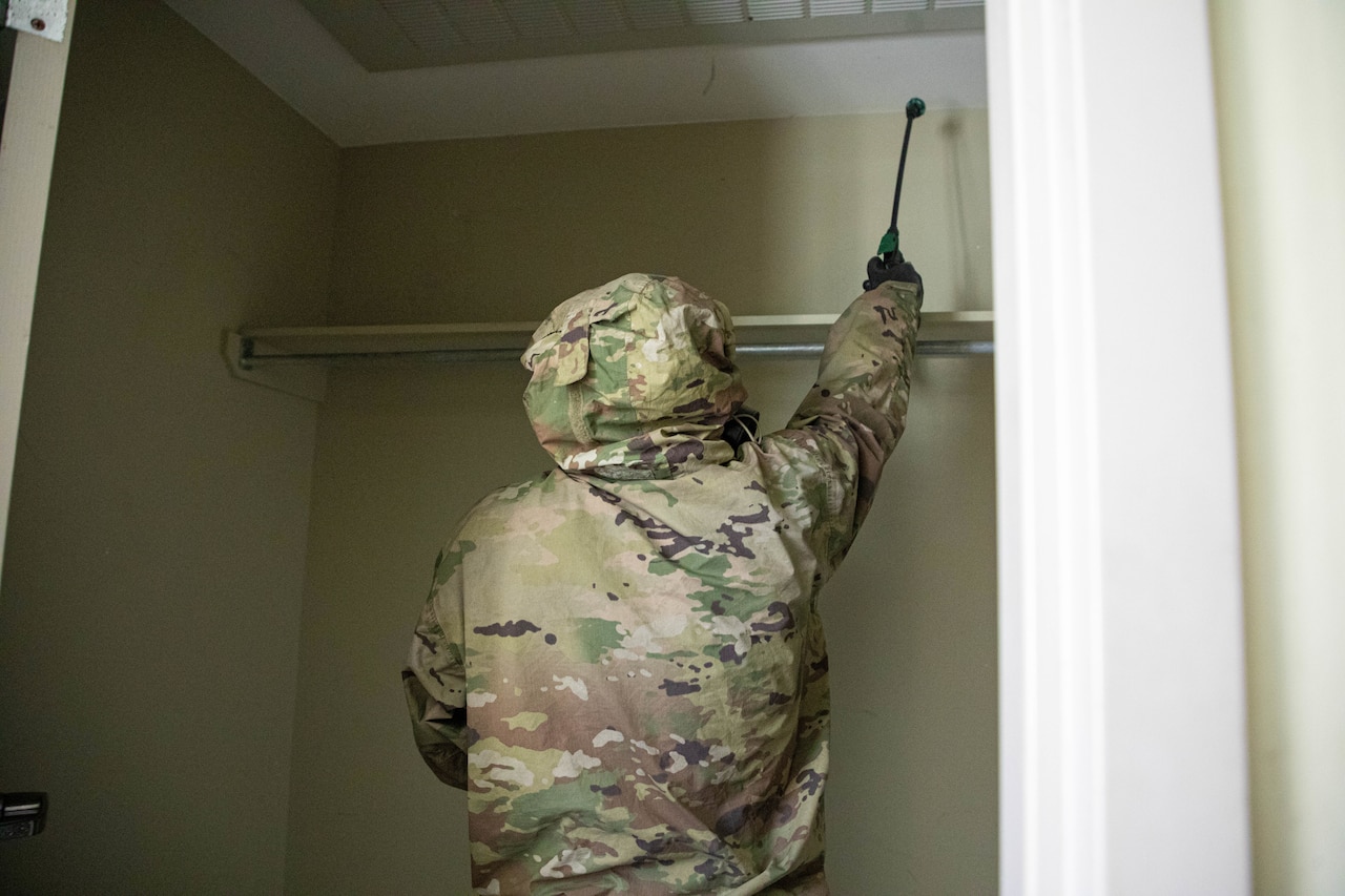Soldiers simulate cleaning a barracks room.