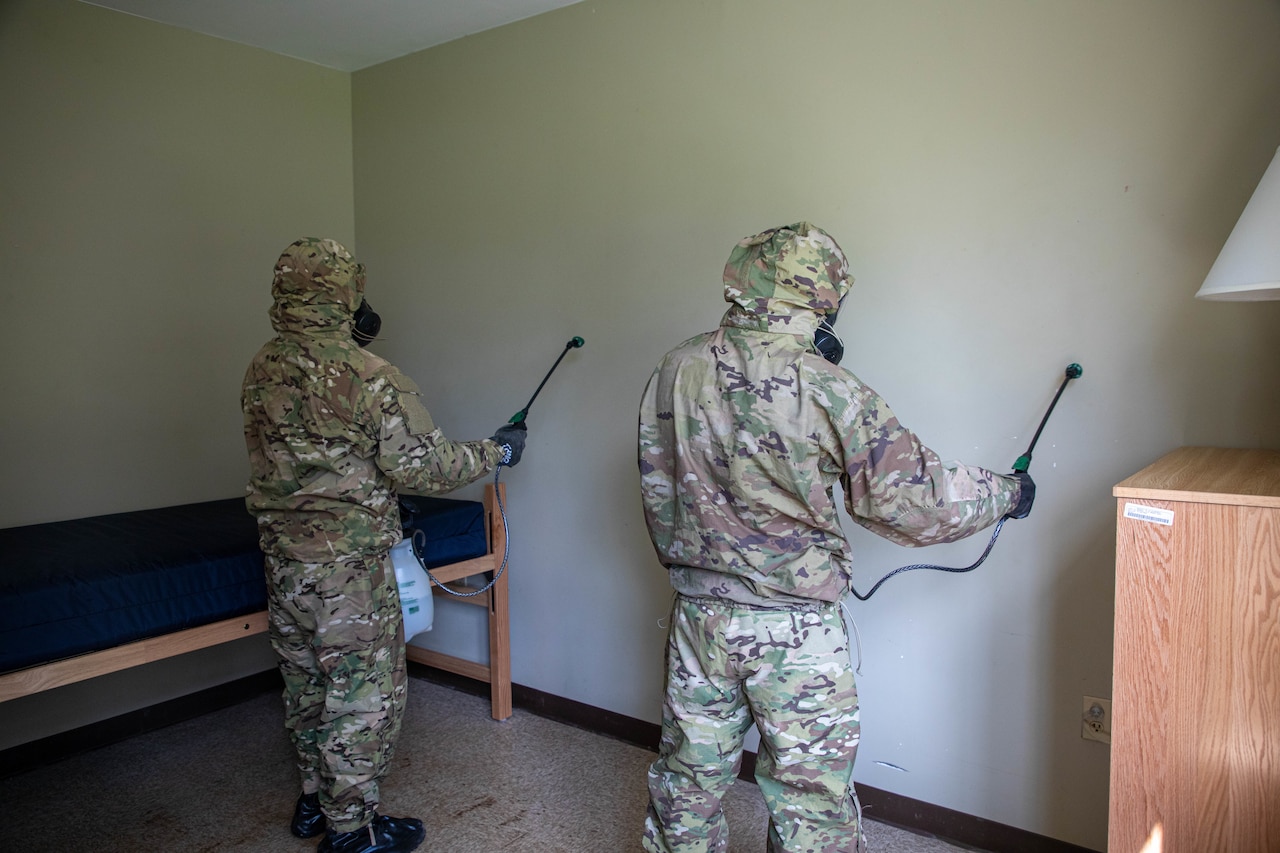 Soldiers simulate cleaning a barracks room.