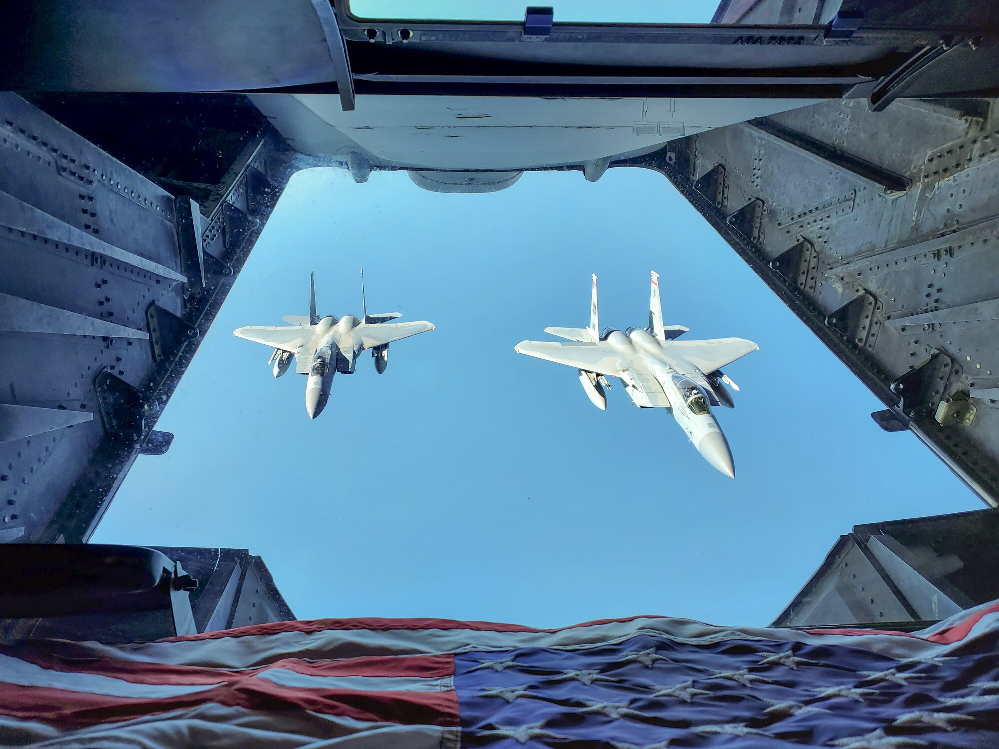 Two F-15 C Eagles with the 104th Fighter Wing, Massachusetts Air National Guard, Westfield, Mass., fly in formation behind a KC-10 Extender operated by the 76th and 78th Air Refueling Squadron, 514th Air Mobility Wing, Joint Base McGuire-Dix-Lakehurst, N.J., over the Atlantic Ocean on May 13, 2020. The 514th performed their scheduled refuel missions in tandem with an #AmericaStrong flyover saluting and thanking all healthcare workers, first responders, and other essential personnel serving on the front lines of the fight against COVID-19. (U.S. Air Force photo by Tech. Sgt. Michael Hong)