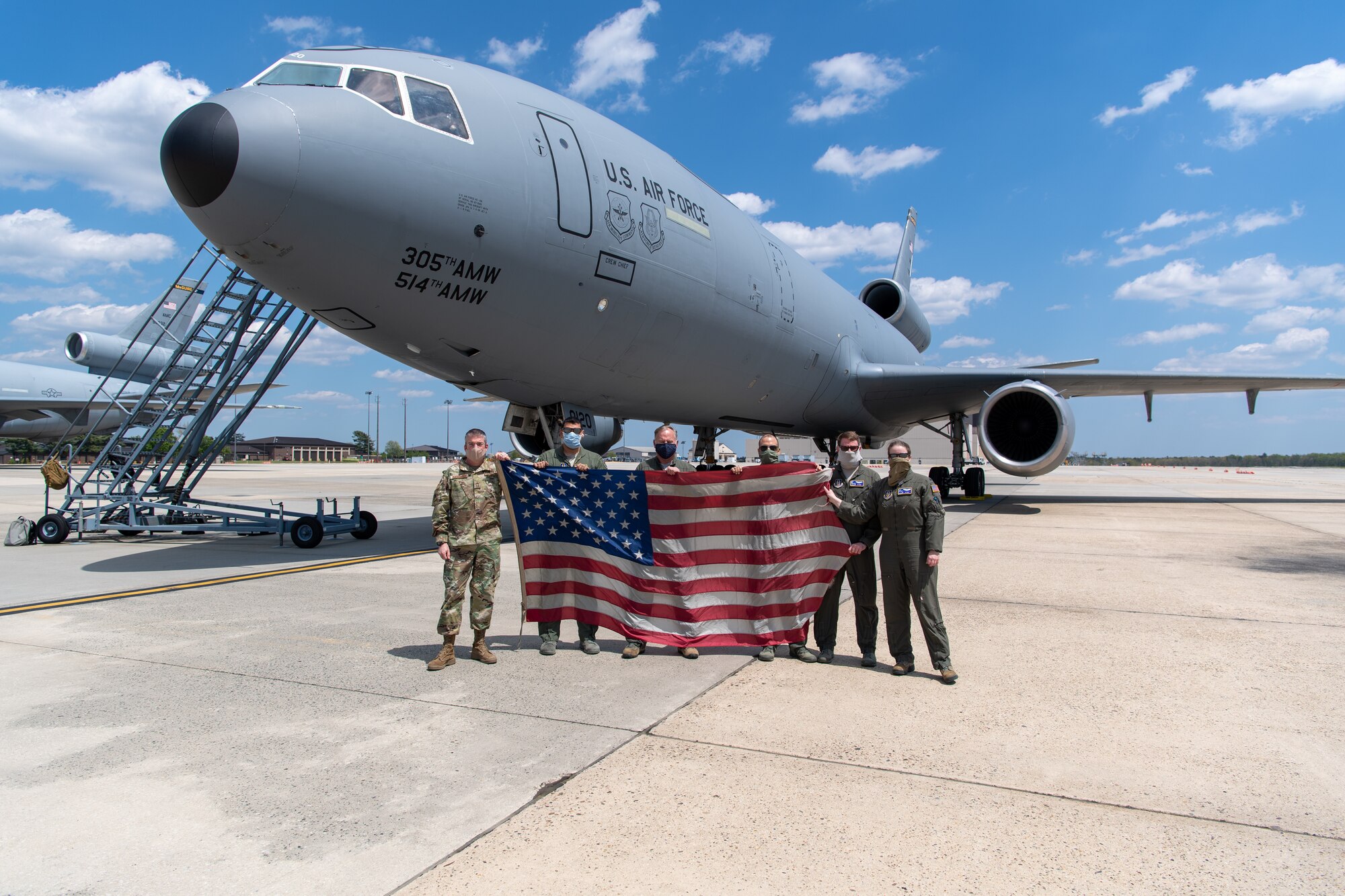 Members with the 76th and 78th Air Refueling Squadron, 514th Air Mobility Wing, Joint Base McGuire-Dix-Lakehurst, N.J., pose for a group photo in front of a KC-10 Extender on May 13, 2020 at JB MDL. The 514th performed their scheduled refuel missions in tandem with an #AmericaStrong flyover saluting and thanking all healthcare workers, first responders, and other essential personnel serving on the front lines of the fight against COVID-19. (U.S. Air Force photo by Tech. Sgt. Michael Hong)