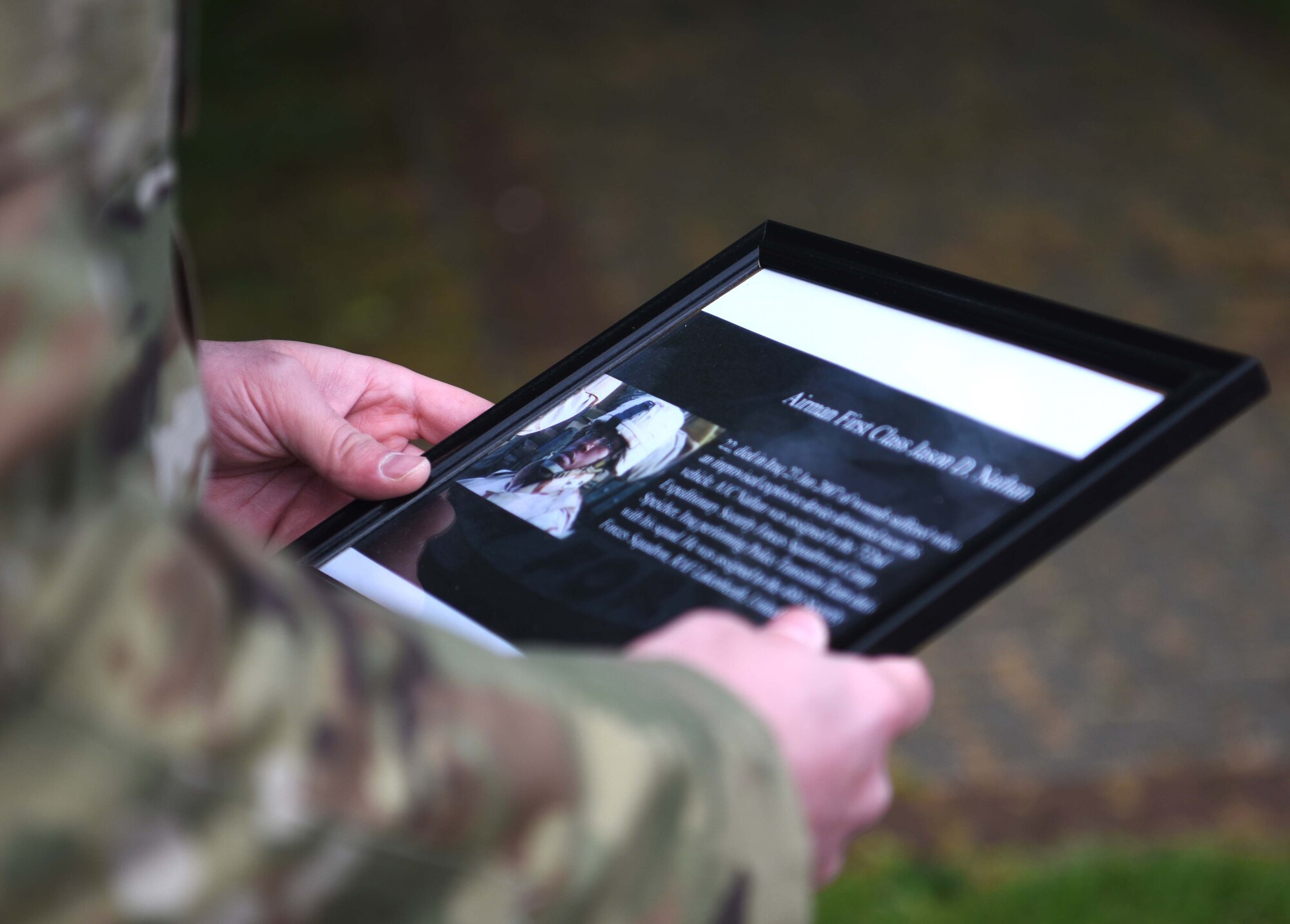 An Airman with the 100th Security Forces Squadron holds a photo of Airman 1st Class Jason D. Nathan during the 100th SFS Memorial Ruck March during National Police Week at RAF Mildenhall, England, May 13, 2020. Nathan, a former 48th Security Forces Squadron Airman, died in Iraq in 2007 from wounds suffered from an IED that detonated near his vehicle. (U.S. Air Force photo by Senior Airman Brandon Esau)