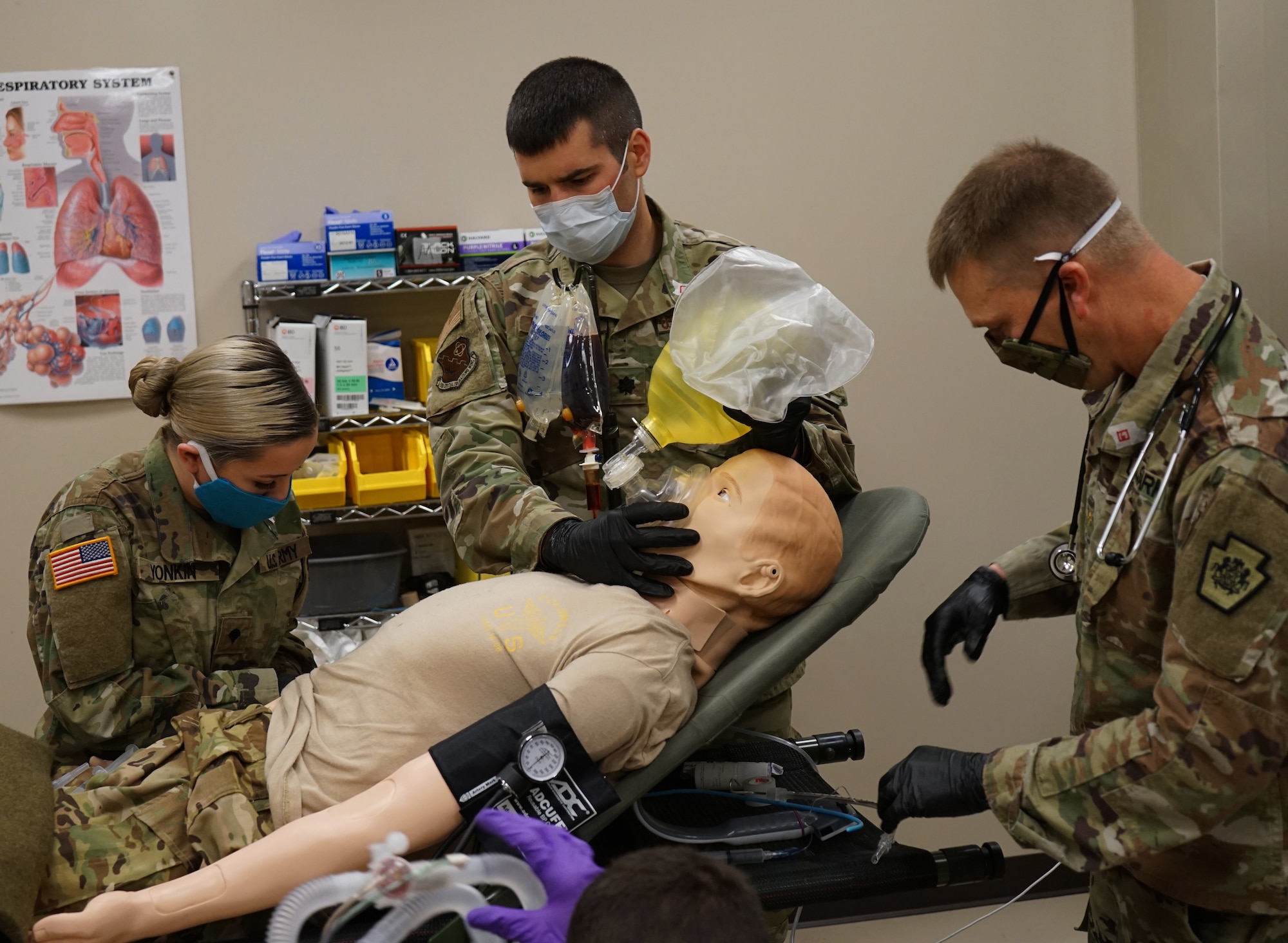 Left to right: Army Spc. Caitlyn Yonkin, combat medic with the medical detachment, Pennsylvania Joint Force Headquarters; Air National Guard Lt. Col. Jared Northrop, pharmacist with the 193rd Special Operations Medical Group Detachment 1; and Army Maj. Brian Walters, physician assistant with the Med. Det., respond to a training scenario at the Medical Simulation Training Center at Fort Indiantown Gap, May 6, 2020.