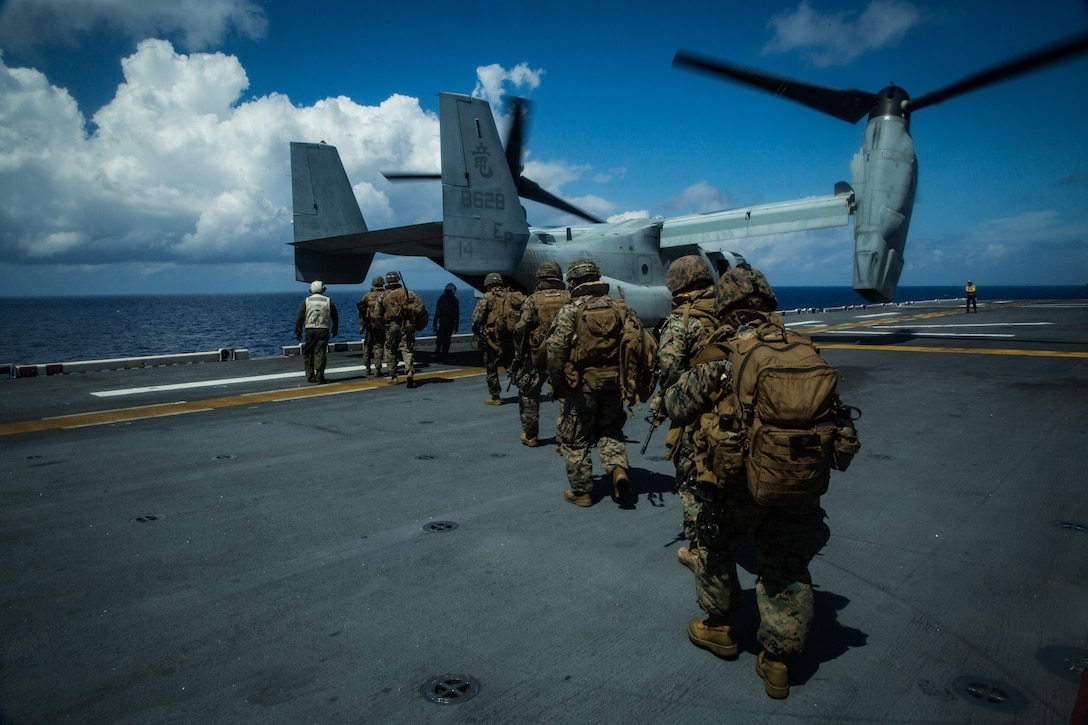 SOUTH CHINA SEA (April 21, 2020) Marines with Battalion Landing Team, 1st Battalion, 5th Marines, 31st Marine Expeditionary Unit (MEU), load onto an MV-22B Osprey tiltrotor aircraft with Marine Medium Tiltrotor Squadron (VMM) 265 (Reinforced), 31st Marine Expeditionary Unit (MEU), during a combat mission rehearsal aboard amphibious assault ship USS America (LHA 6). The Osprey is a long-range troop transport aircraft that can be deployed at a moment’s notice, enabling the Blue-Green team to rapidly respond to crises. America, flagship of the America Expeditionary Strike Group, 31st MEU team, is operating in the U.S 7th Fleet area of operations to enhance interoperability with allies and partners and serve as a ready response force to defend peace and stability in the Indo-Pacific region. (Marine Corps photo by Sgt Audrey M. C. Rampton)