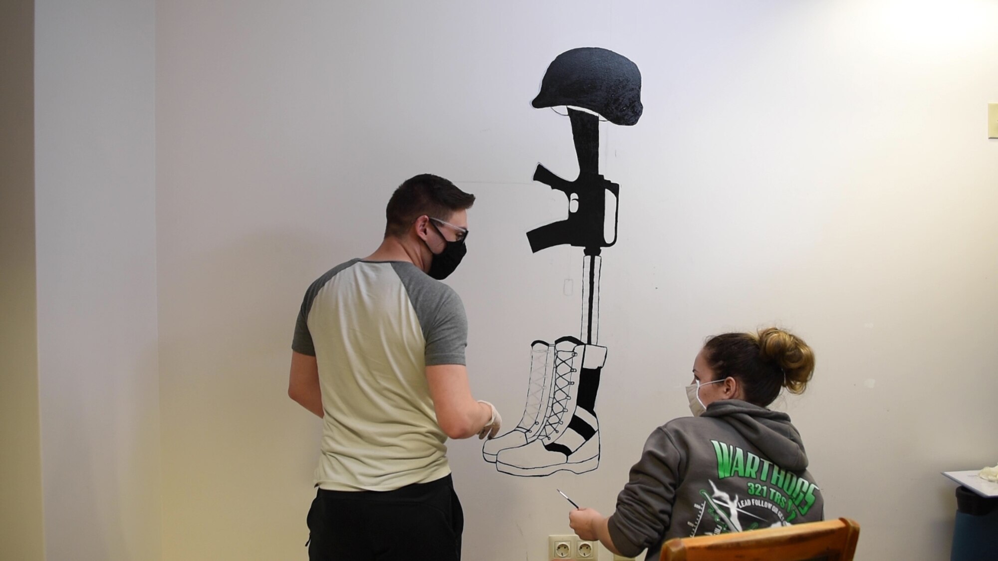 Photo of Airman painting a mural