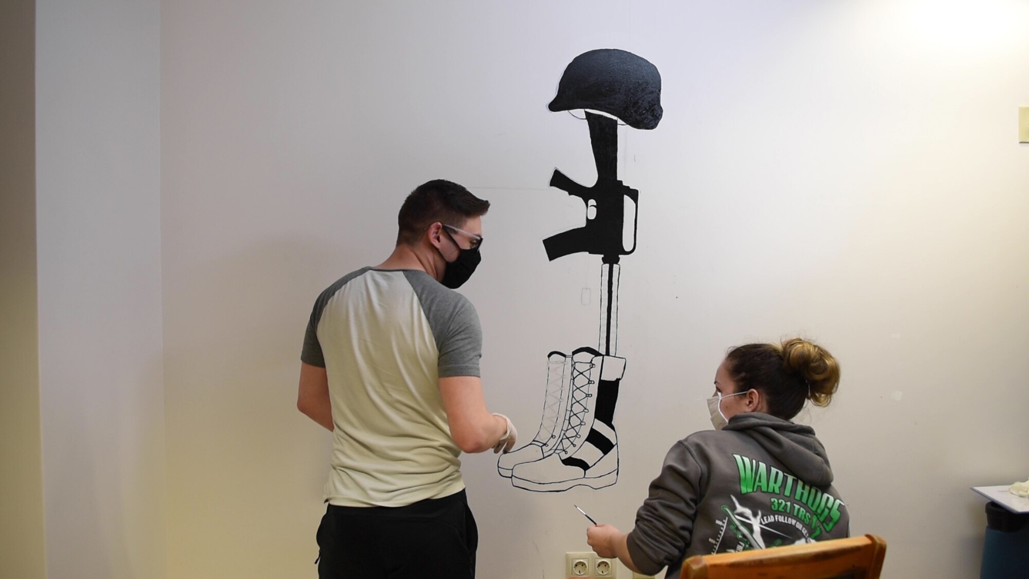 U.S. Air Force Senior Airman Tyler Menz, 39th Security Forces Squadron unit training instructor, left, and Airman 1st Class Anna Whittington, 39th SFS commander’s support staff, talk while painting a mural April 23, 2020, at Incirlik Air Base, Turkey. The Airmen embarked on this project to honor security forces heritage in the security forces dormitories. (U.S. Air Force photo by Staff Sgt. Joshua Magbanua)