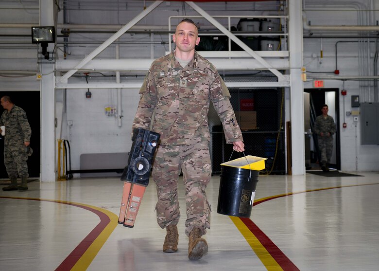 Staff Sgt. Brandon Miller, a heating, ventilation, air conditioning and refrigeration (HVACR) technician at the 910th Civil Engineer Squadron at YARS and Ohio State Highway Patrolman at the Ashtabula post in Ohio carries a few tools of his trade after completing a job in Hangar 305, Jan. 12, 2020.