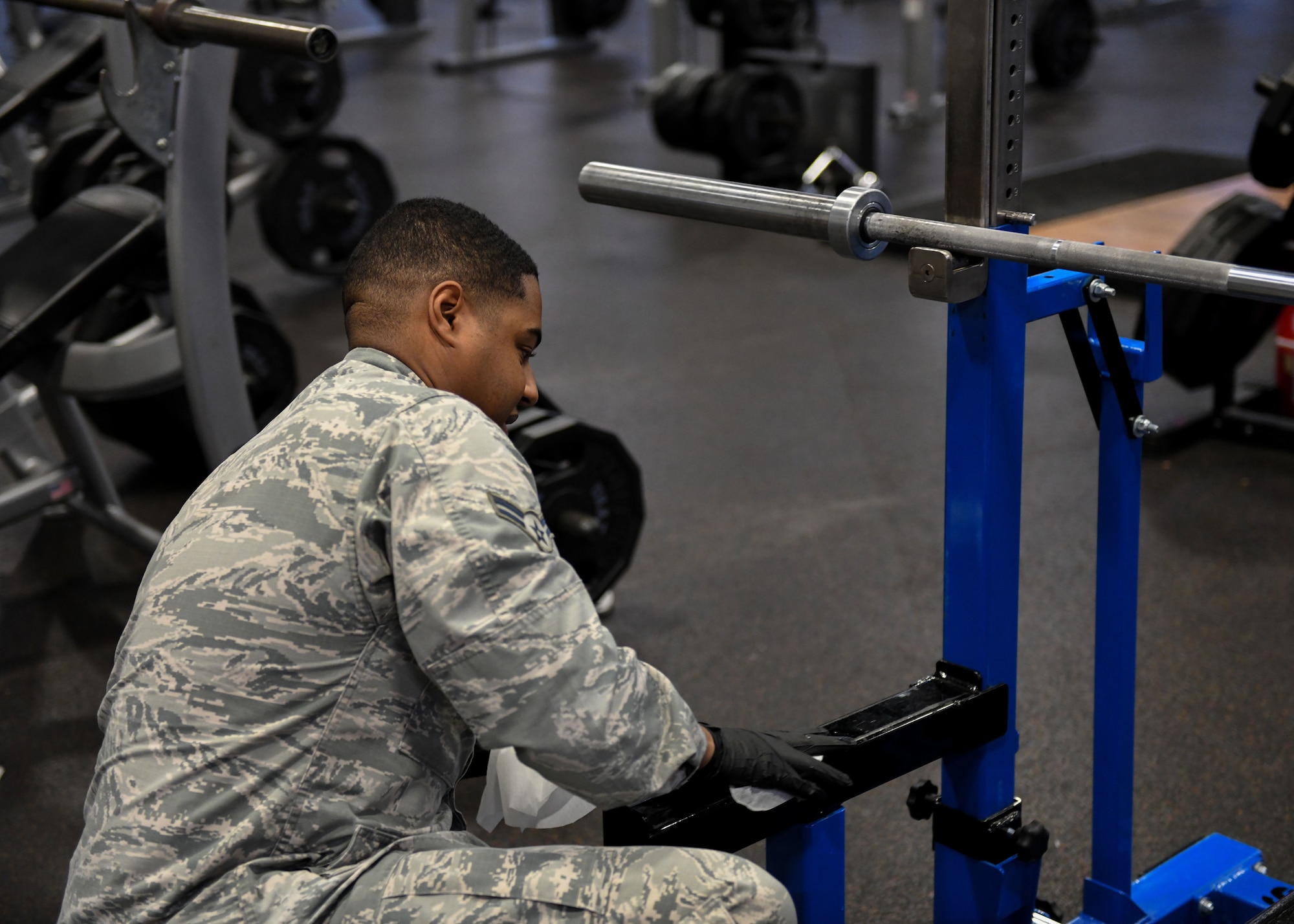 Airmen sanitize gym equipment