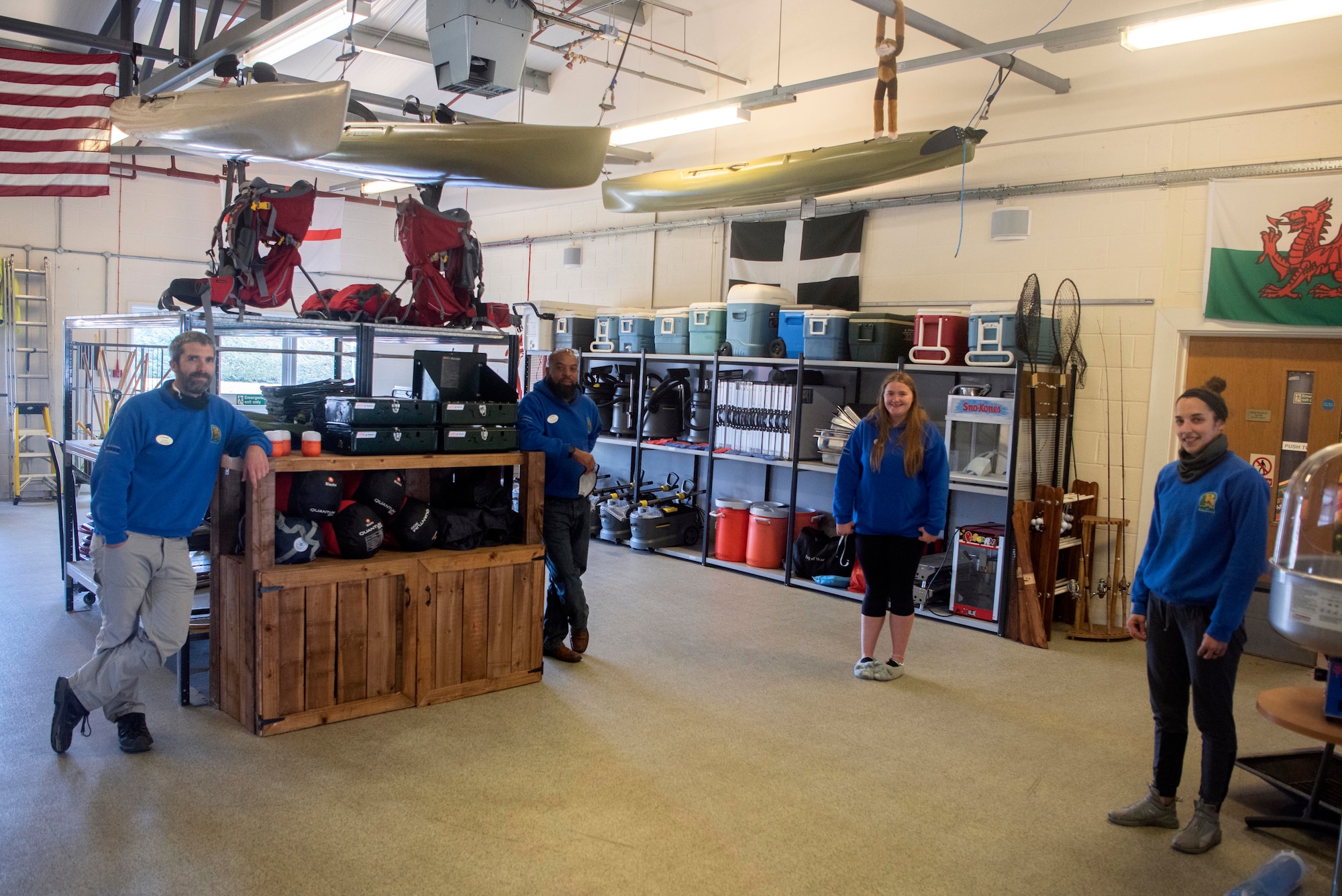 The 100th Force Support Squadron Outdoor Recreation Center team poses for a photo inside their building at RAF Mildenhall, England, May, 11, 2020. From having to cancel trips and plan future ones, to adjusting how they take rentals and what type of equipment they give out, the team has adapted their operations to the restrictions imposed by COVID-19. (U.S. Air Force photo by Airman 1st Class Joseph Barron)