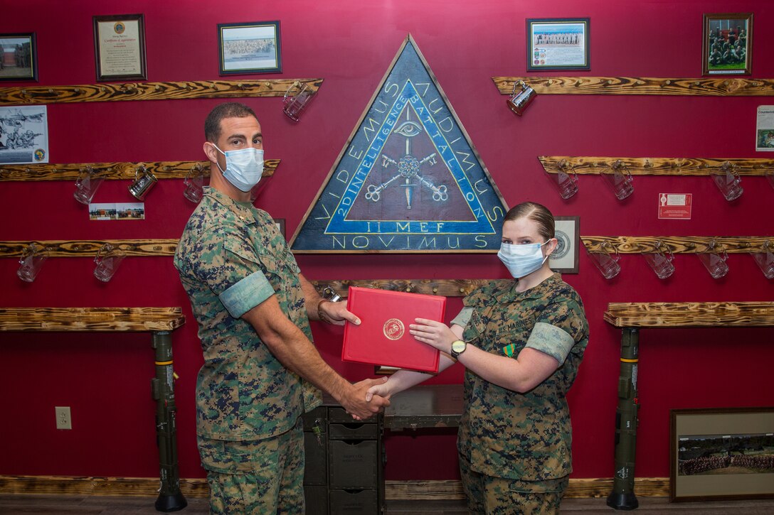 (Left) U.S. Marine Corps Maj. Patrick Coffman, presents a Navy and Marine Corps Achievement Medal to Lance Cpl. Zeelie Scruggs, an intelligence specialist with 2nd Intelligence Battalion, II MIG, at Camp Lejeune, N.C., May 8.