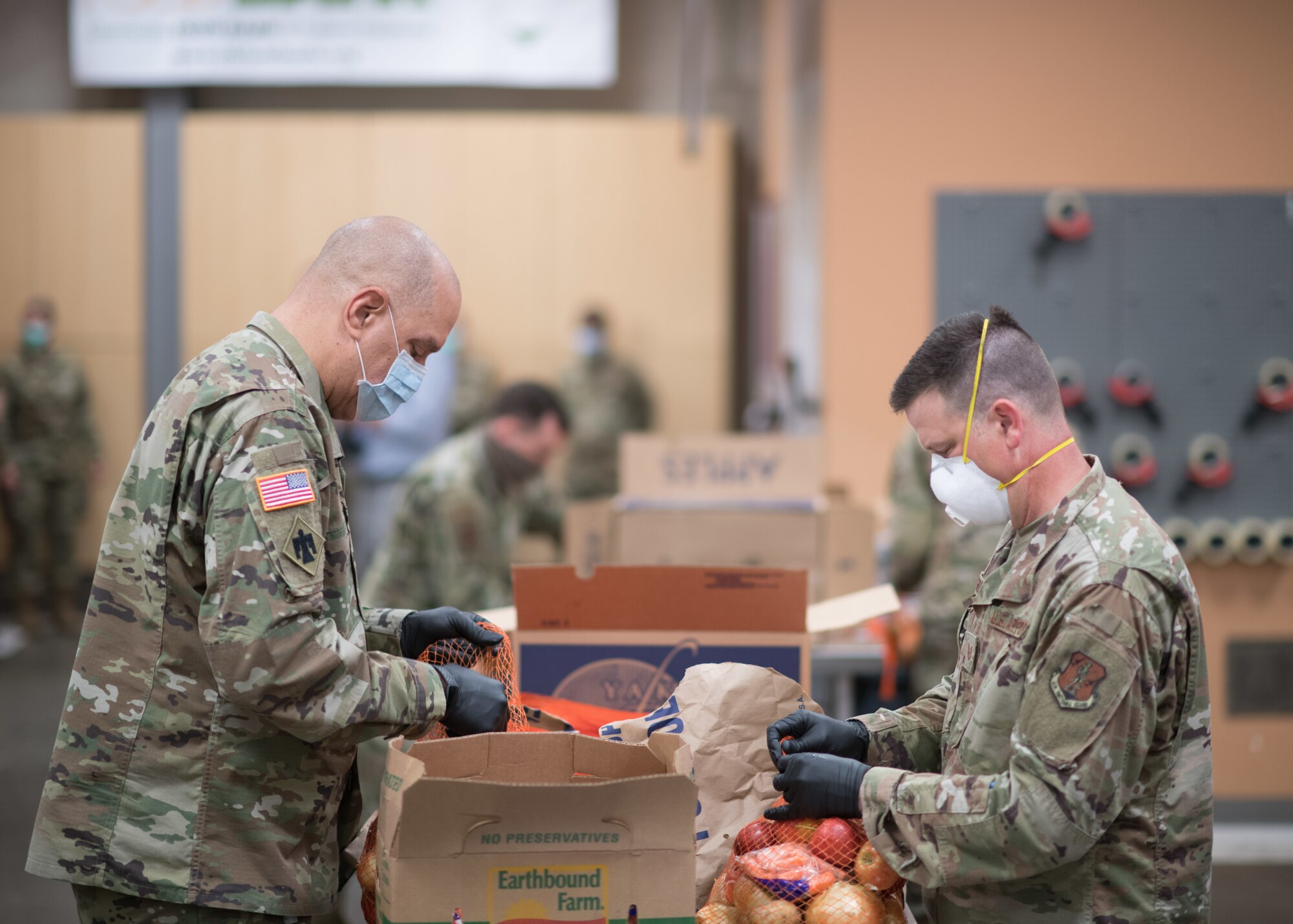Oklahoma Army National Guard Maj. Gen. Michael Thompson, left, the adjutant general for Oklahoma, packs produce bags with Oklahoma Air National Guard Tech. Sgt. Luke Goodnight, right, a member of the 138th Fighter Wing, at the Community Food Bank of Eastern Oklahoma in Tulsa, Oklahoma, April 29, 2020. Due to COVID-19, Guardsmen have been working daily to replace the vital volunteer force that usually pack the food until it is safe to have them return. At the direction of Governor Kevin Stitt, Oklahoma Guardsmen were activated to serve in various roles in support of the State's COVID-19 response including support to food banks. (U.S. Air National Guard photo by Tech. Sgt. Rebecca Imwalle)