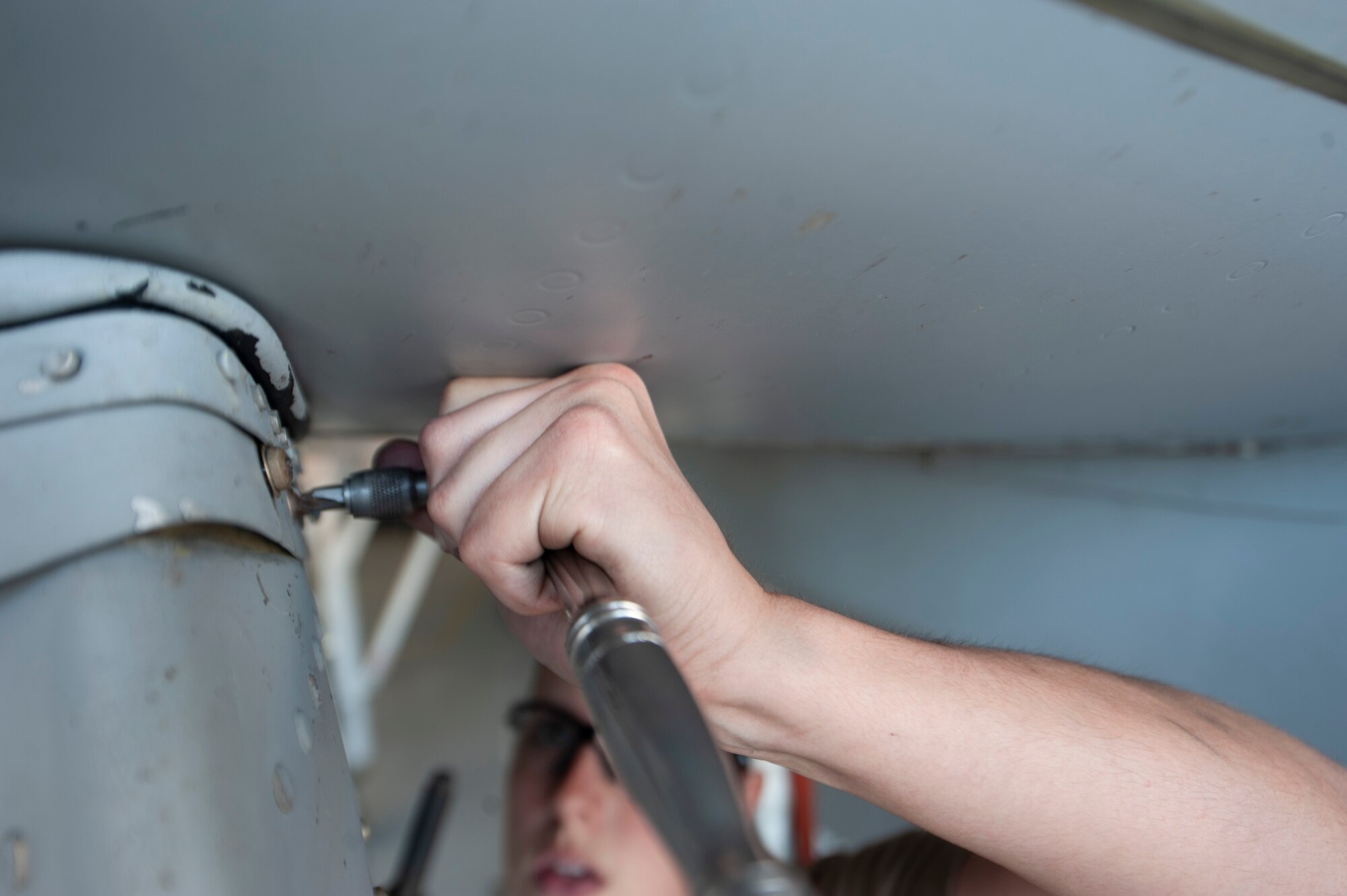 A photo of an Airman unscrewing a bolt