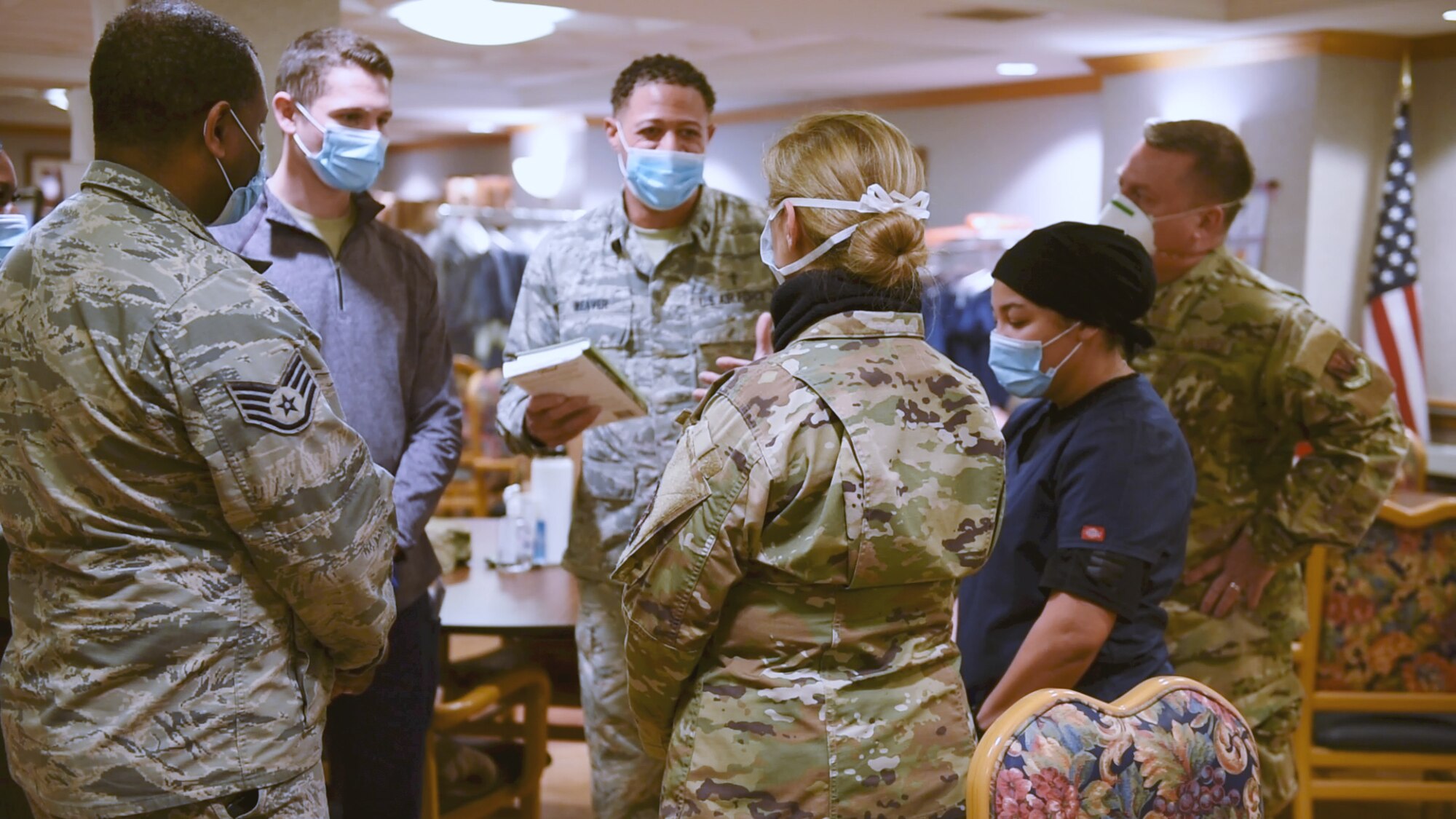 Chaplain speaks with Airmen standing in a circle