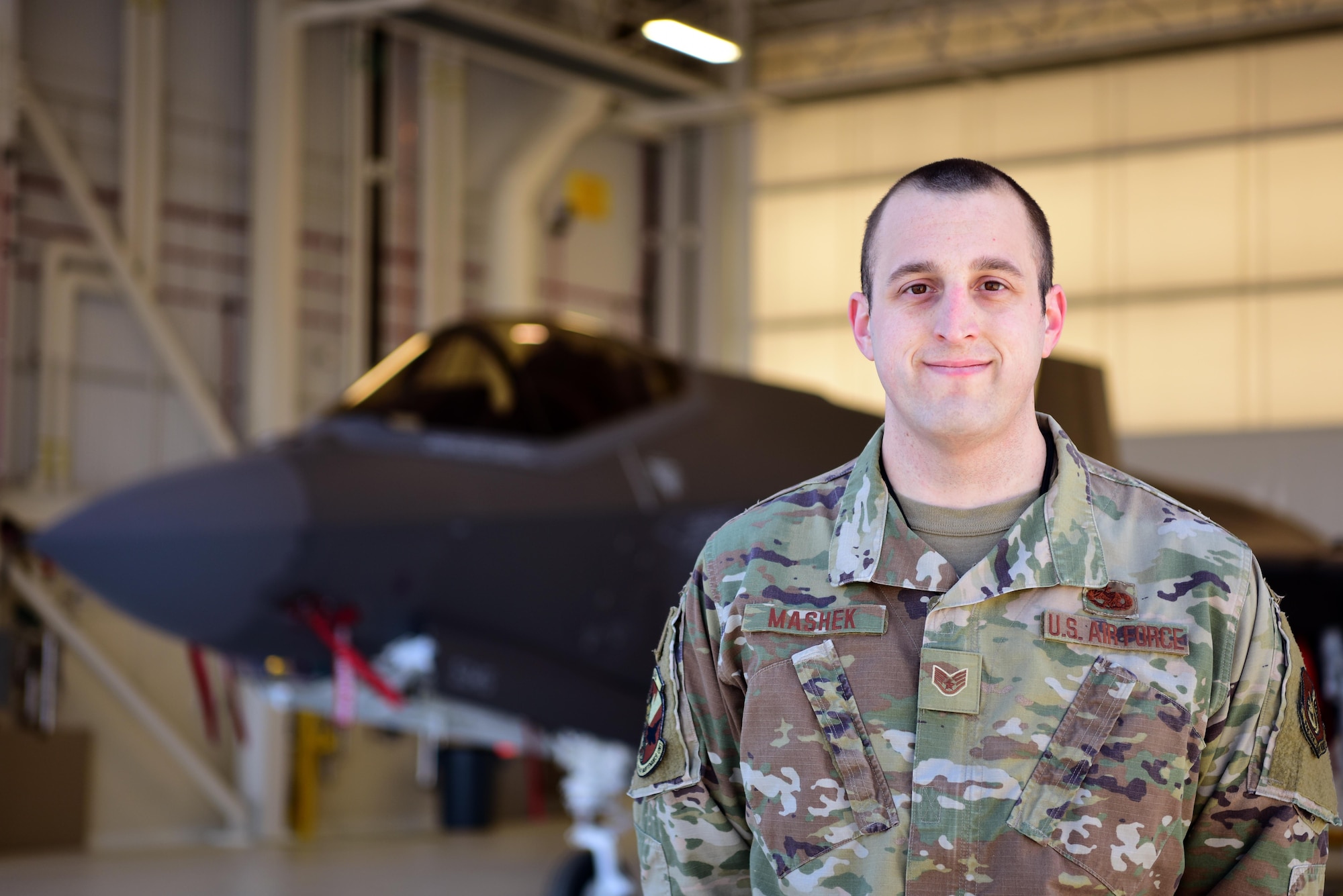 U.S. Air Force Staff Sgt. Christopher Mashek, a 356th Aircraft Maintenance Unit F-35A Lightning II crew chief, poses for a photo in front of an F-35A at Eielson Air Force Base, Alaska, May 1, 2020.
