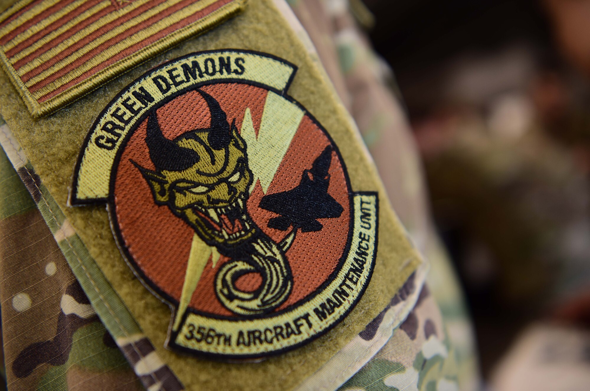 U.S. Air Force Staff Sgt. Christopher Mashek, a 356th Aircraft Maintenance Unit F-35A Lightning II crew chief, dons a Green Demons unit patch at Eielson Air Force Base, Alaska, May 1, 2020.