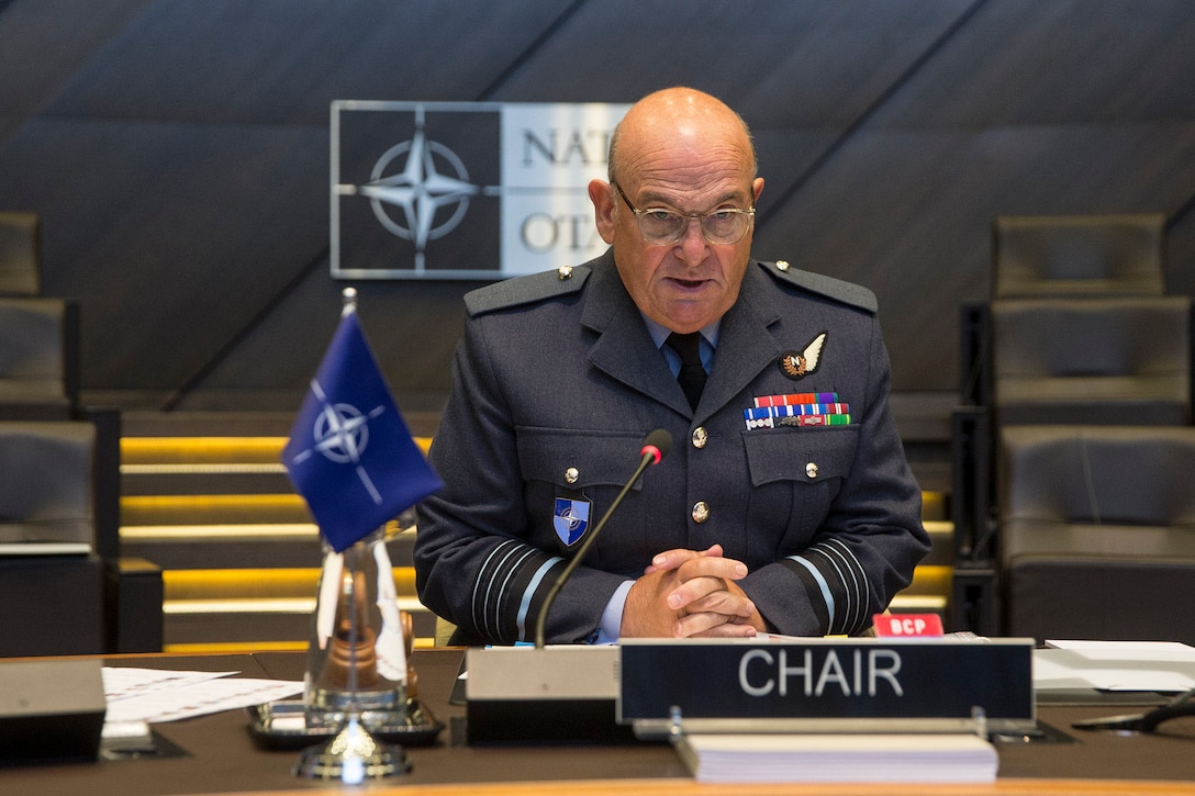 A British service member sits at a desk.