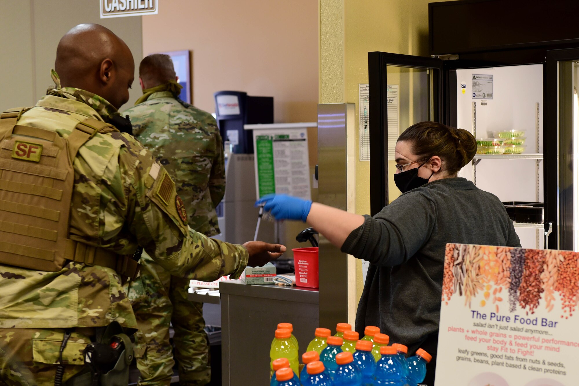 Sarah Brembry, Guardian Dining Facility (DFAC) cashier, hands sauces to a customer at Creech Air Force Base, Nevada, April 17, 2020.