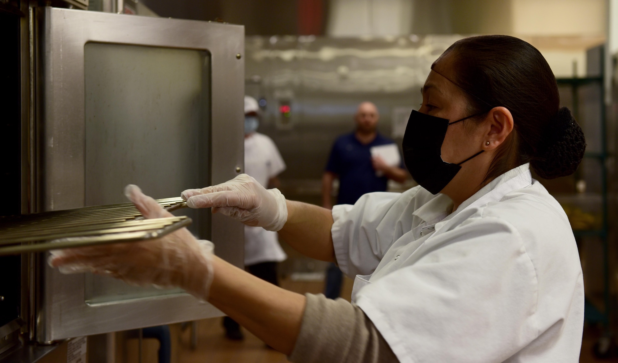 Patricia Munoz, Guardian Dining Facility (DFAC) food service worker, replaces oven racks after cleaning them at Creech Air Force Base, Nevada, April 17, 2020.