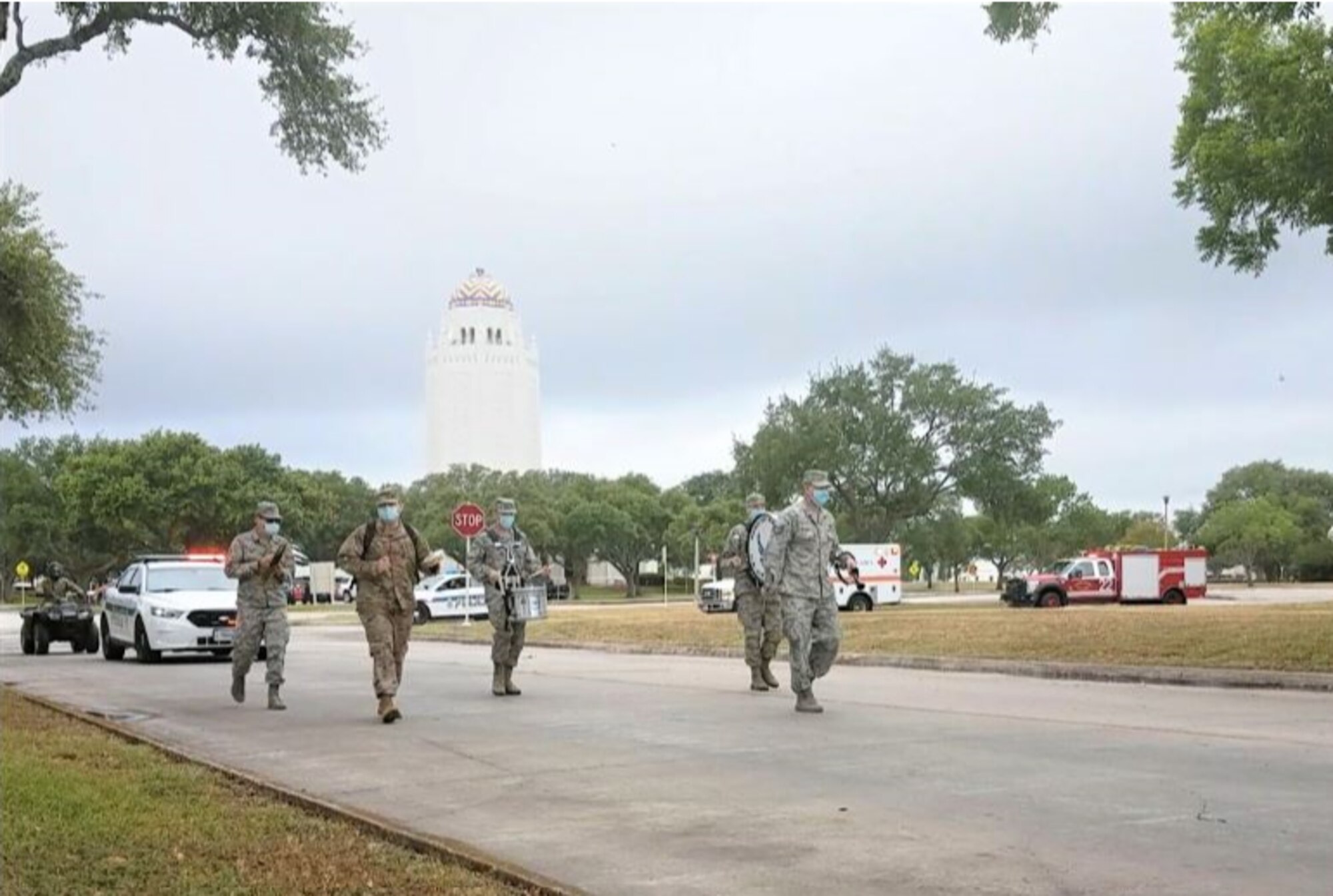 Air Force Band of the West percussionists march behind the lead vehicle during the National Police Week parade on C Street at Joint Base San Antonio-Randolph, Texas, May 13, 2020. Due to COVID-19 and social distancing, the 902nd Security Forces Squadron invited other first responders to join them in parading through base housing so the community could show their appreciation.