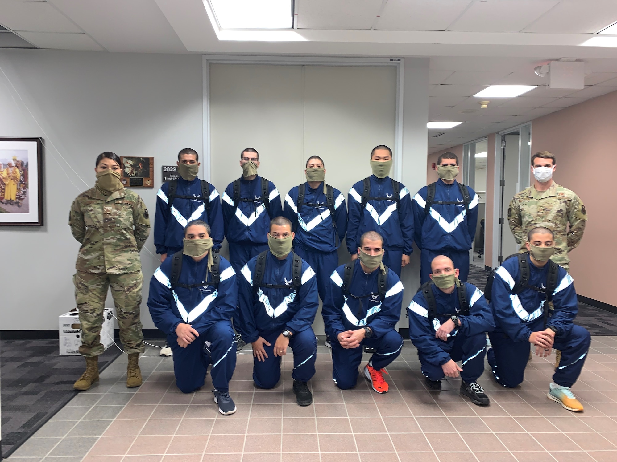 US Air Force Echo Flight trainees pose for a picture in the Commandant’s hallway. Due to COVID-19 precautions, they are wearing facemasks as required. They had to stop by campus for  their placement exam before returning to the 737 TRSS learning lab for their classroom distance learning.