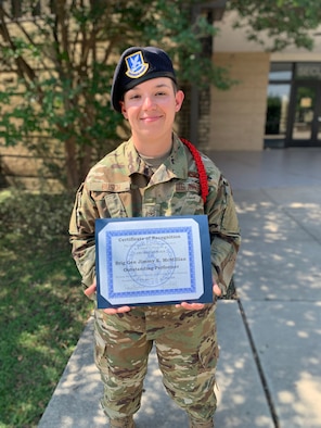 Airman Shannon Busch stands holding an award. (Courtesy Photo)