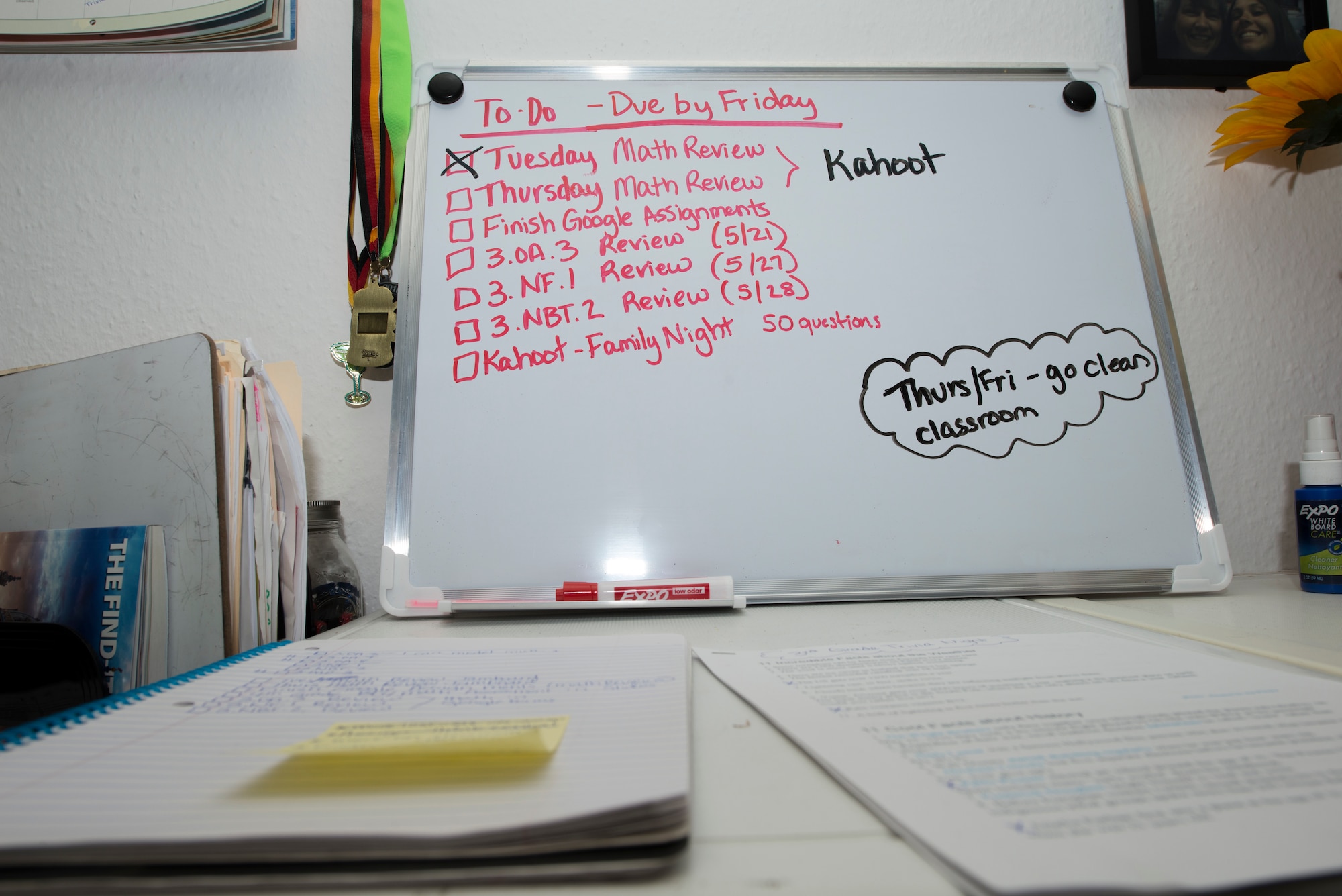 A photo displaying notebooks and a dry erase board.