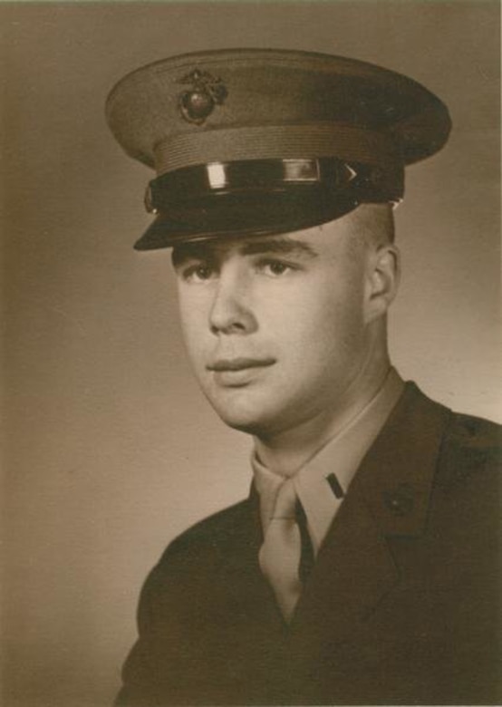 A man in a military hat and uniform poses for an official photo.
