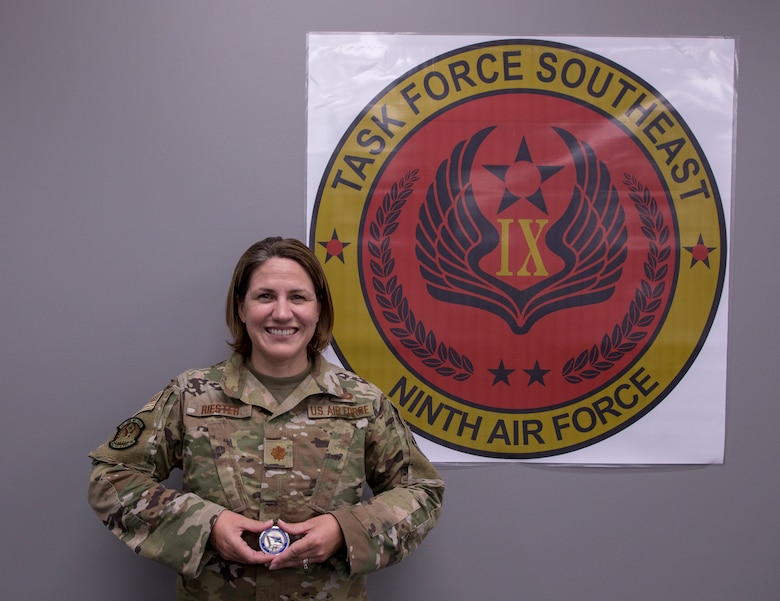 Major Melissa Reister in photograph holding CSAF coin.