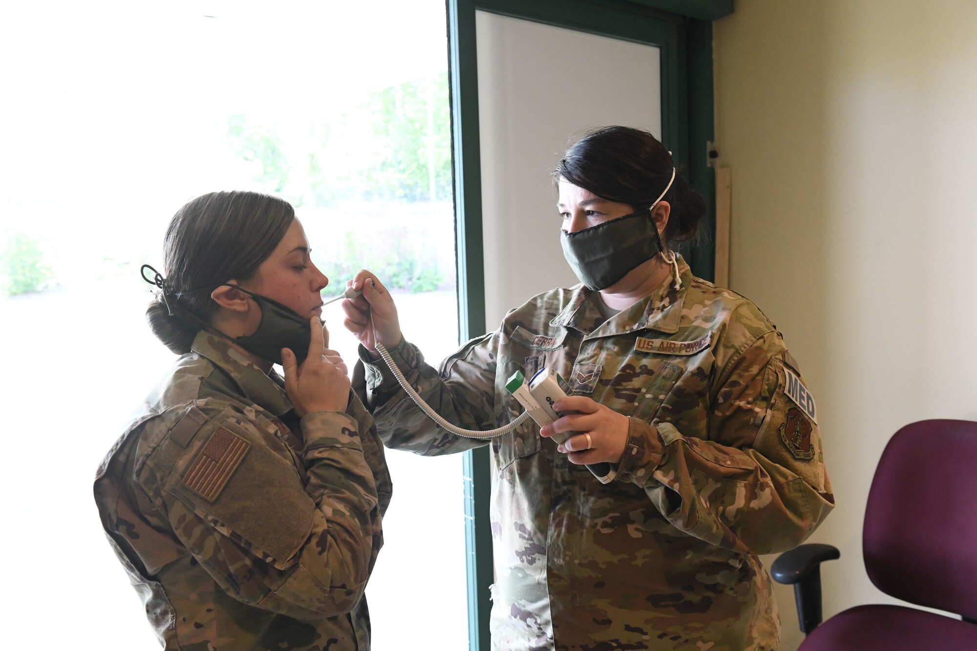 U.S. Air Force Senior Airman Marissa Cerra (right) practices checking an incoming patient for fever and abnormal health while conducting drills prior to accepting live patients, at the North Carolina National Guard Medical Support Shelter (MSS), Central North Carolina, April 29, 2020. TThe MSS is intended to act as an overflow shelter for hospital patients not infected with the COVID-19 virus and is maned by a joint task force of Army and Airforce National Guard medical staff.