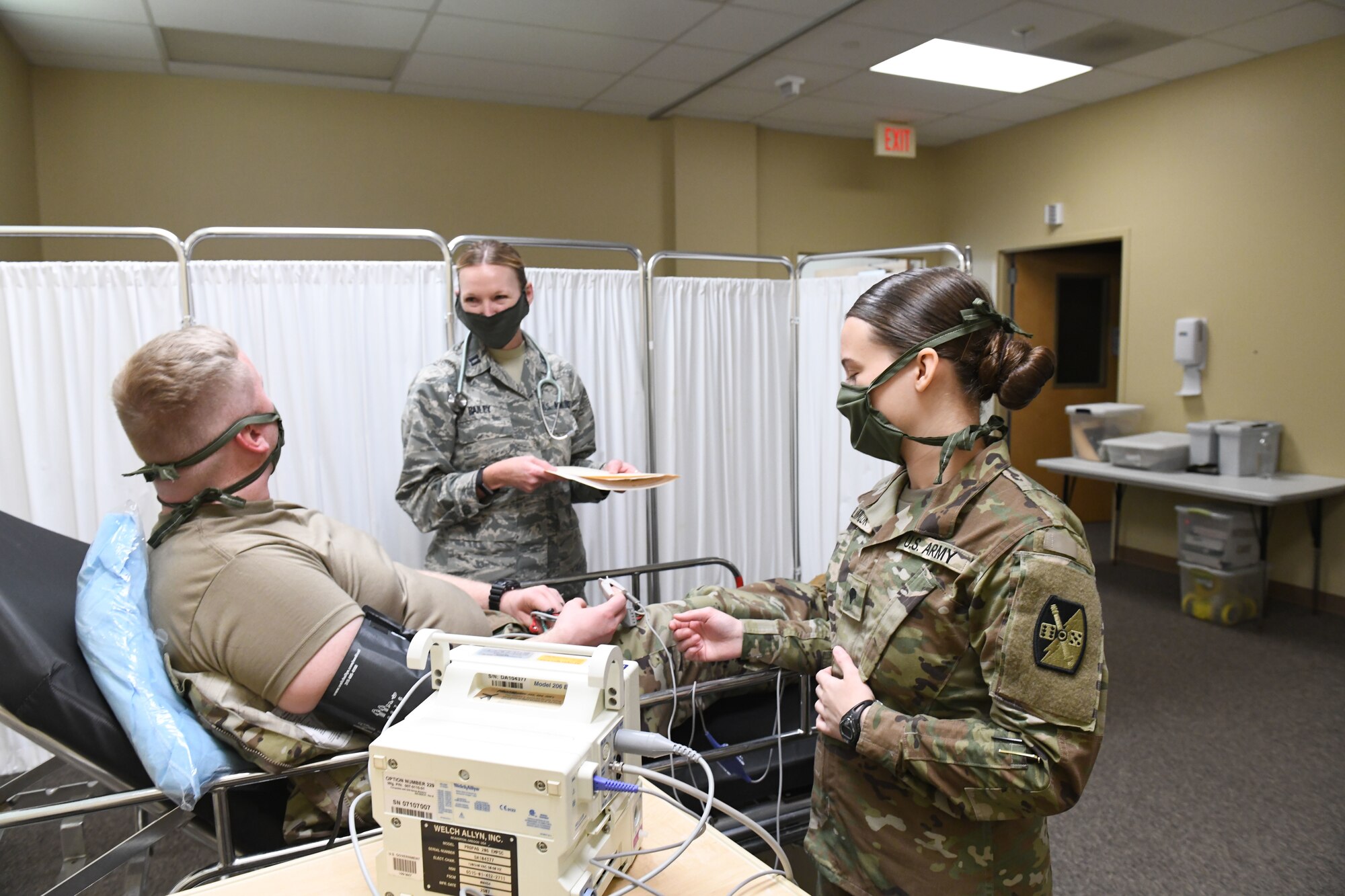 U.S. Air Force Capt. Lauri Bailey, a registered nurse for the 145th Medical Group (left) and U.S. Army Specialist Samantha Klimczak, a medic with the North Carolina Army National Guard (right) practice treating a simulated patient, while conducting drills prior to the arrival of live patients, at the North Carolina National Guard Medical Support Shelter (MSS), Central North Carolina, April 29, 2020. The MSS is intended to act as an overflow shelter for hospital patients not infected with the COVID-19 virus and is maned by a joint task force of Army and Airforce National Guard medical staff.