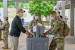 Soldiers wash their hands and social distance.