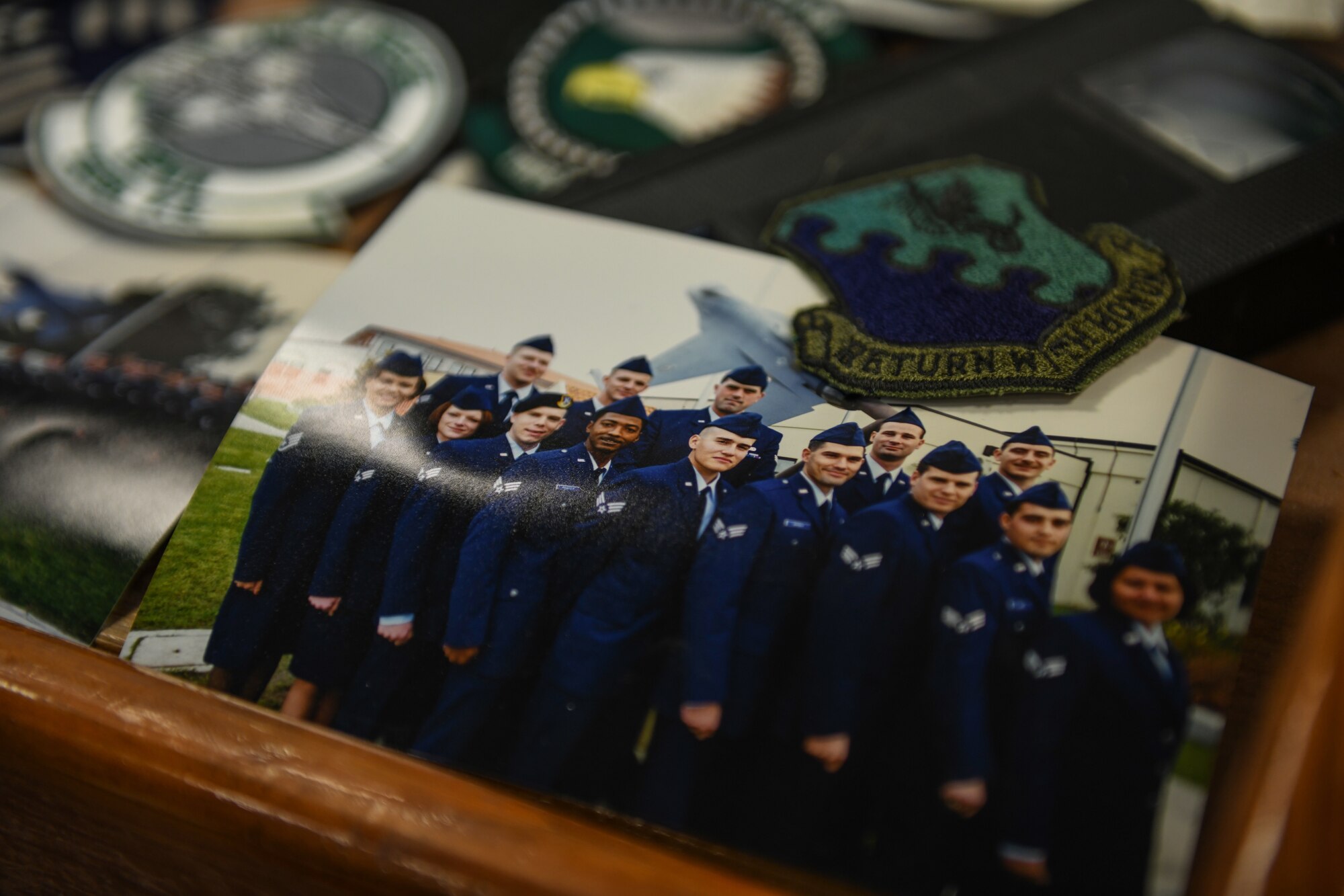 A picture of class 99-A Aviano Airman Leadership School, from a time capsule, is displayed with a wyvern patch and videotape at Aviano Air Base, Italy, May 15, 2020. The class was made up of two flights with a total of 23 students. (U.S. Air Force photo by Airman 1st Class Ericka A. Woolever)