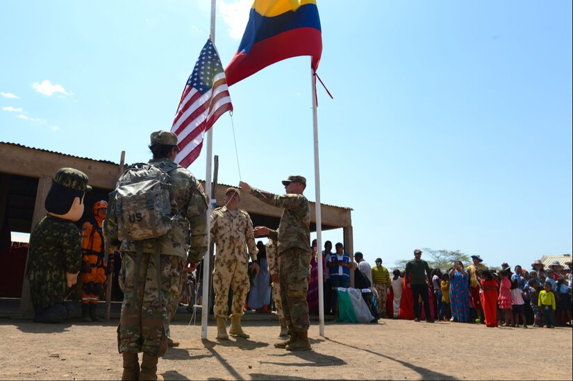 Participants at a medical readiness exercise raise an American flag owned by Chief Warrant Officer 4 Joval Eblen III alongside the flag of Colombia during Exercise Vita in Tres Bocas, La Guajira, Colombia March 12, 2020.