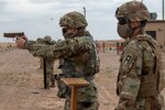 Spc. Henry Jacob, a military police Soldier assigned to 253 Military Police Company, Tennessee National Guard, fires an M17 pistol at McGregor Range Complex, New Mexico, May 10, 2020, while Sgt. Zachary Yarbrough, right, an observer coach/trainer assigned to 2-340 Training Support Battalion, 5th Armored Brigade, watches.