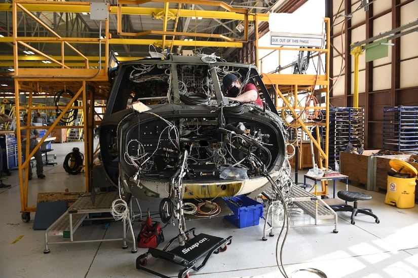Mary King, aircraft electrician in the avionics/electrical branch at the Corpus Christi Army Depot, Texas, installs the instrument panel wiring harness as part of the assembly and repair of the UH-60L to UH-60V upgrade.(U.S. Army photo by Ervey Martinez)