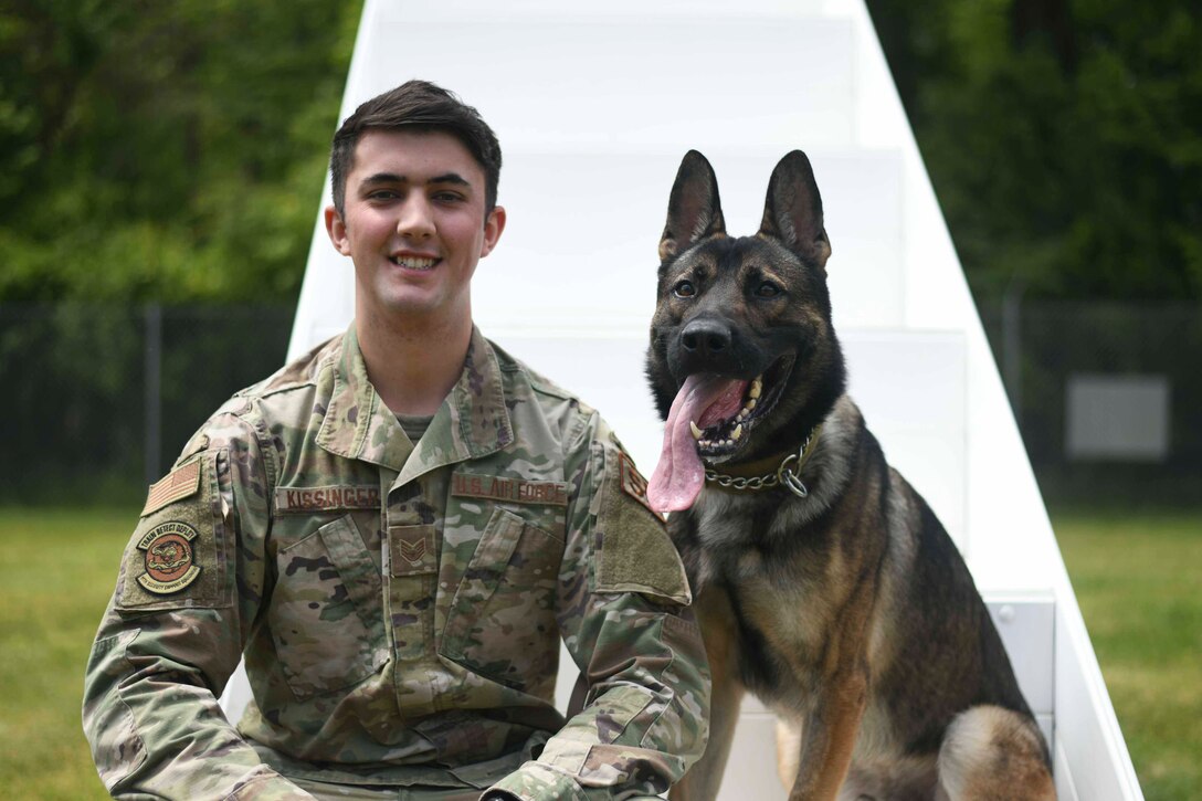 Staff Sgt. Trenton Kissinger, 11th Security Support Squadron military working dog handler, poses for a photo with Edo, MWD, at Joint Base Andrews, Md., May 14, 2020. Each handler is paired with a MWD based on their personalities in order to have successful teamwork. Police Week is held annually during whichever week May 15th falls to honor all law enforcement officers past and present. (U.S. Air Force photo by Airman 1st Class Spencer Slocum)