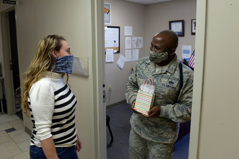 17th Training Wing Violence Prevention Integrator, Donna Casey, presents U.S. Air Force Staff Sgt. Alonso Hall, 316th Training Squadron Military Training Leader, a gift bag in the 316th TRS dormitory on Goodfellow Air Force Base, Texas, May 1, 2020. Gift bags, snacks or thank you cards were given out to MTLs on Goodfellow as part of the Adopt-An-MTL program, thanking them for all that they do. (U.S. Air Force photo by Senior Airman Zachary Chapman)