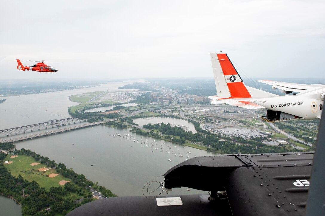 Aircraft fly over a large river and city.