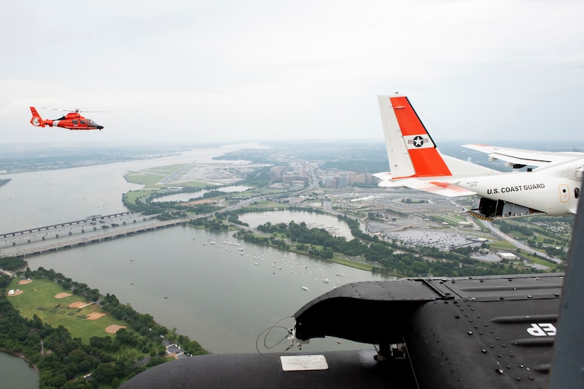 Aircraft fly over a large river and city.