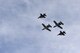A photo a four-ship formation performing a flyover.